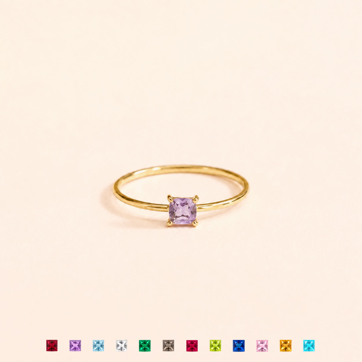 Gold ring with a purple gemstone on a beige background