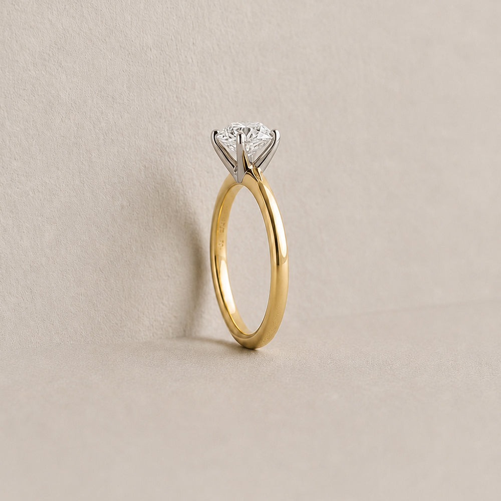 Gold ring with a diamond on a beige background
