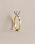 Gold ring with a diamond on a beige background
